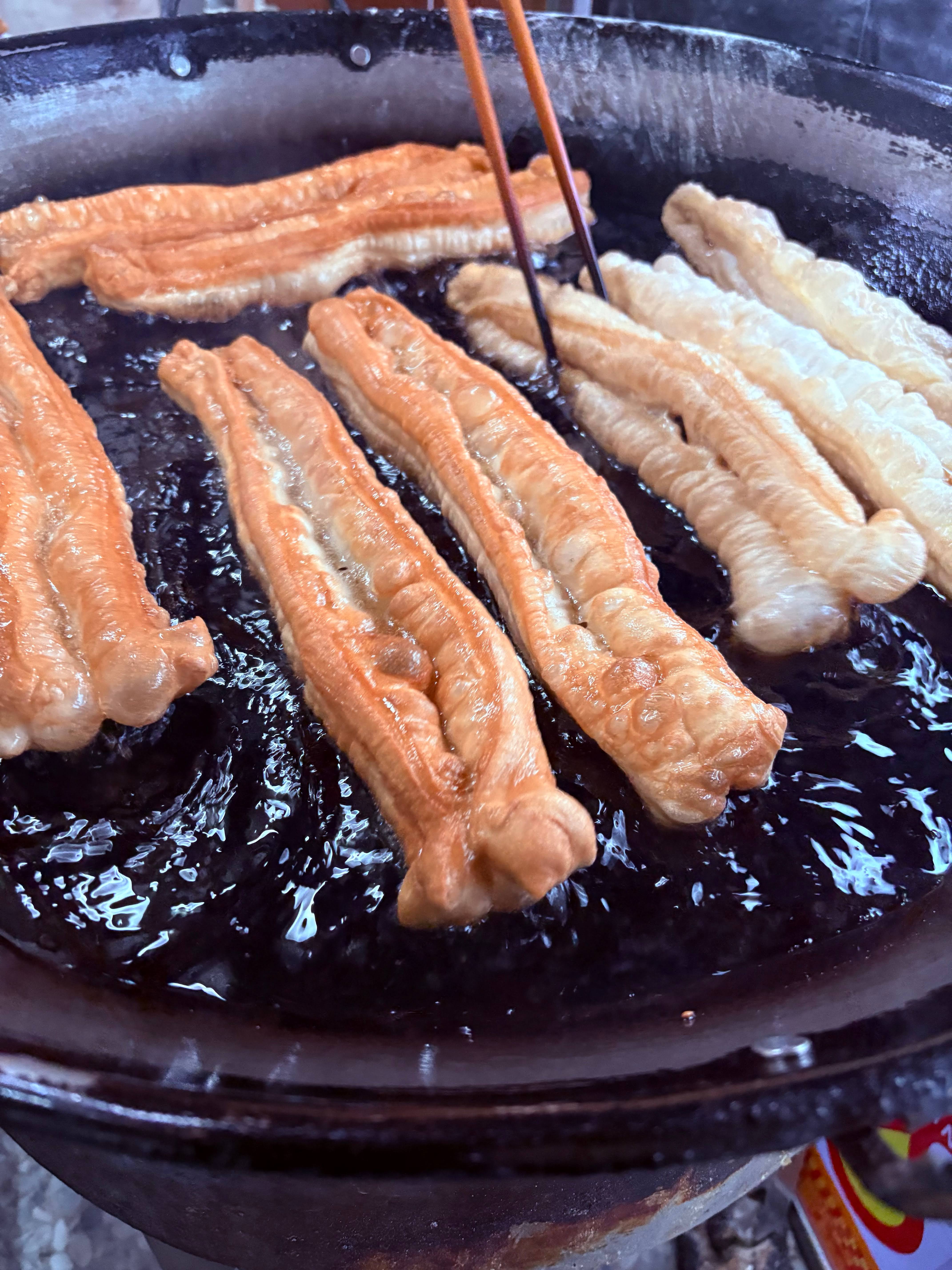 金黃酥脆的油條正在鍋中油炸